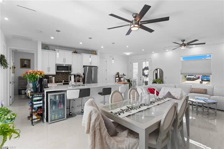 Dining room with beverage cooler, french doors, recessed lighting, and a ceiling fan