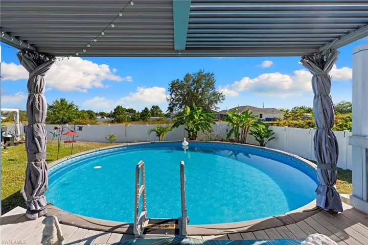 View of swimming pool with a fenced backyard and a pergola