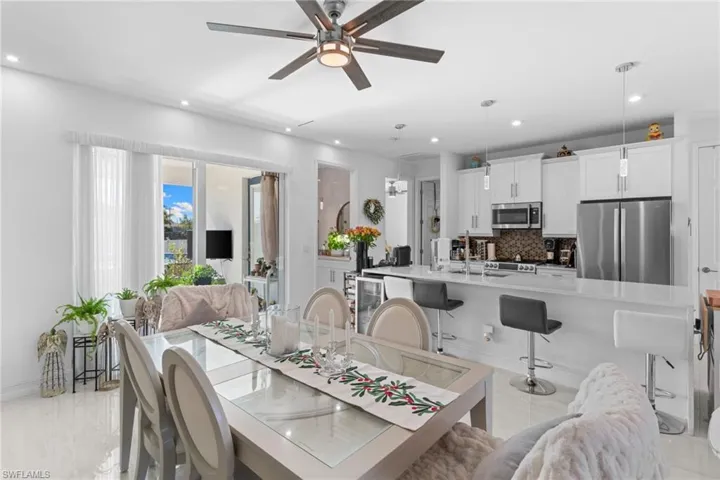 Dining space with a ceiling fan, beverage cooler, and recessed lighting