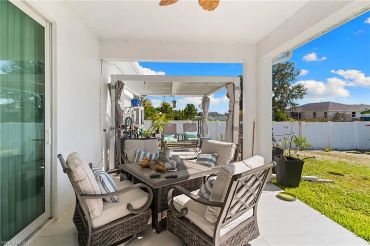 Fenced backyard featuring outdoor dining area, a patio, and a ceiling fan