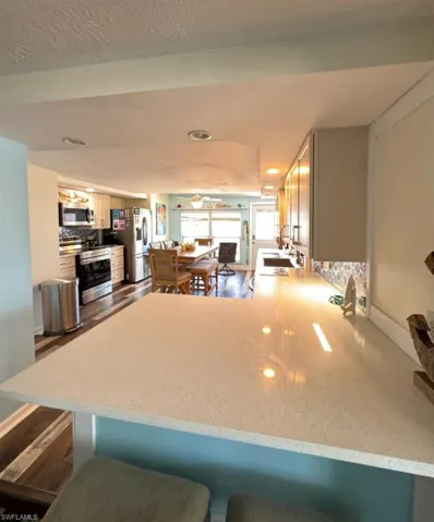 Kitchen featuring stainless steel appliances, a peninsula, backsplash, and light stone counters