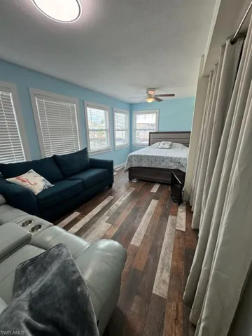 Bedroom featuring dark wood finished floors, a textured ceiling, and a ceiling fan