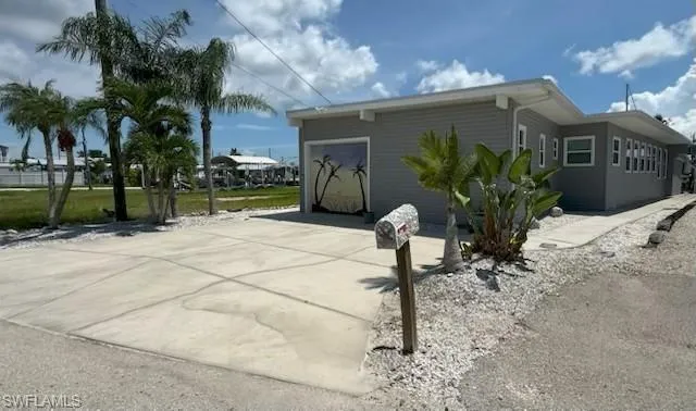 Back of property with an attached garage and driveway