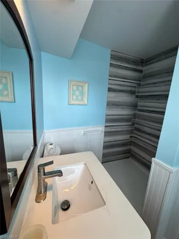 Bathroom with a wainscoted wall and vanity