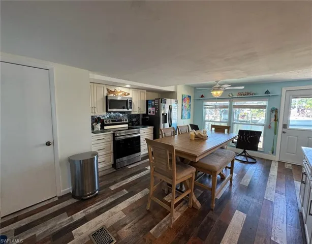 Dining space with dark wood finished floors and a ceiling fan