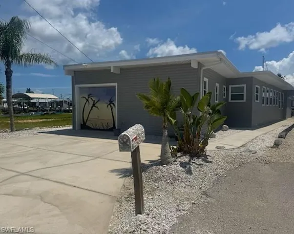 View of side of home with an attached garage and concrete driveway