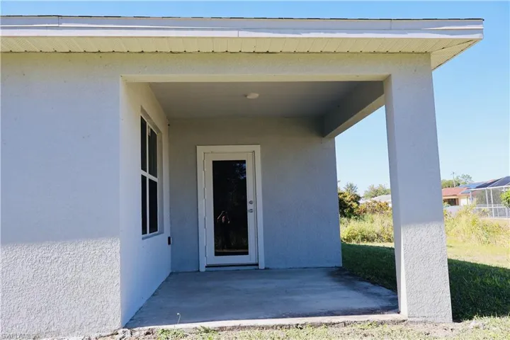 Entrance to property featuring stucco siding and a patio area