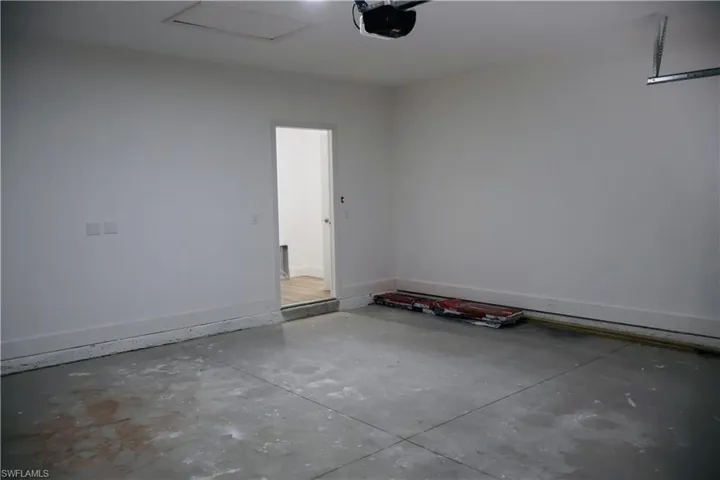Garage with a garage door opener and baseboards