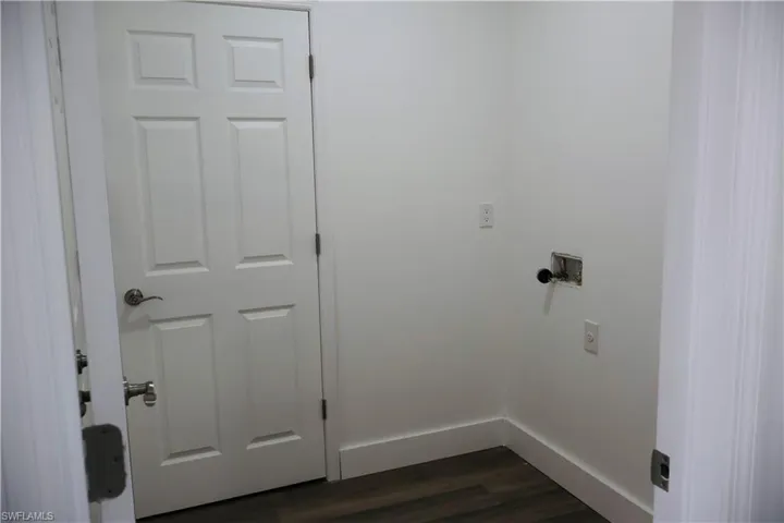 Laundry room with dark wood-type flooring and washer hookup