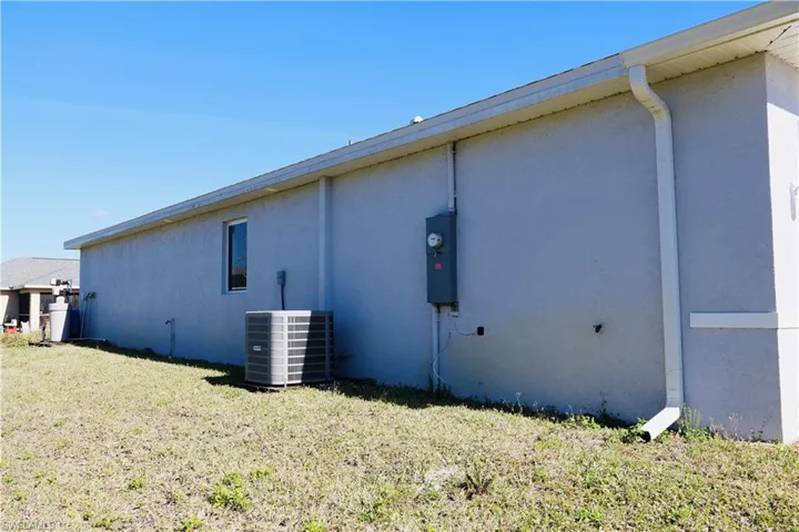 Rear view of house with a yard and stucco siding