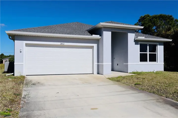 Prairie-style house with roof with shingles, stucco siding, concrete driveway, and an attached garage