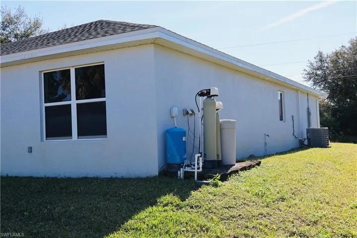 View of property exterior featuring stucco siding and a yard