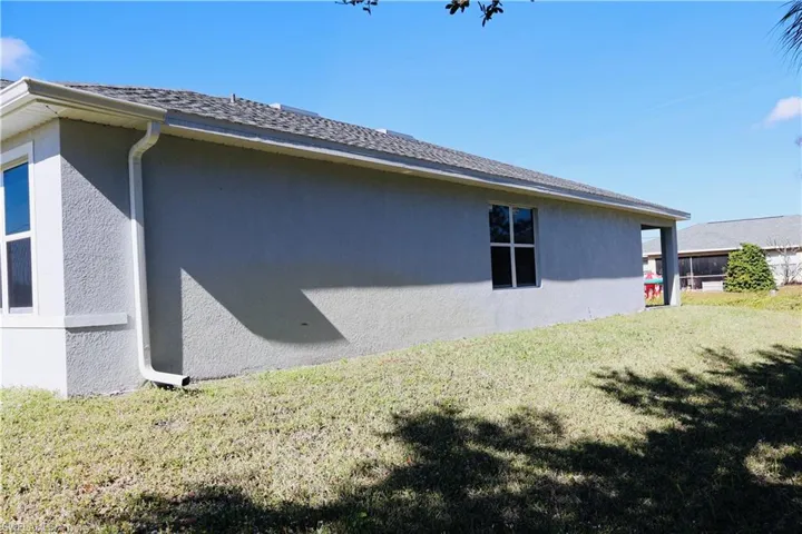 View of property exterior with stucco siding and a yard