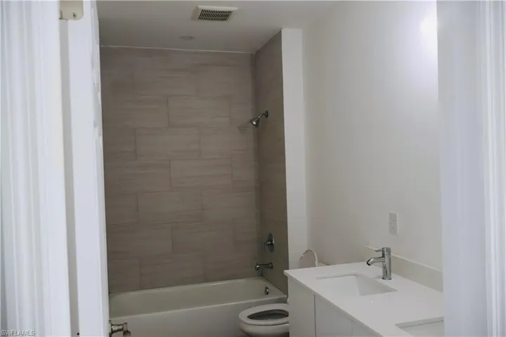 Full bathroom with double vanity and bathtub / shower combination