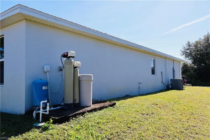 View of side of property featuring stucco siding and a lawn
