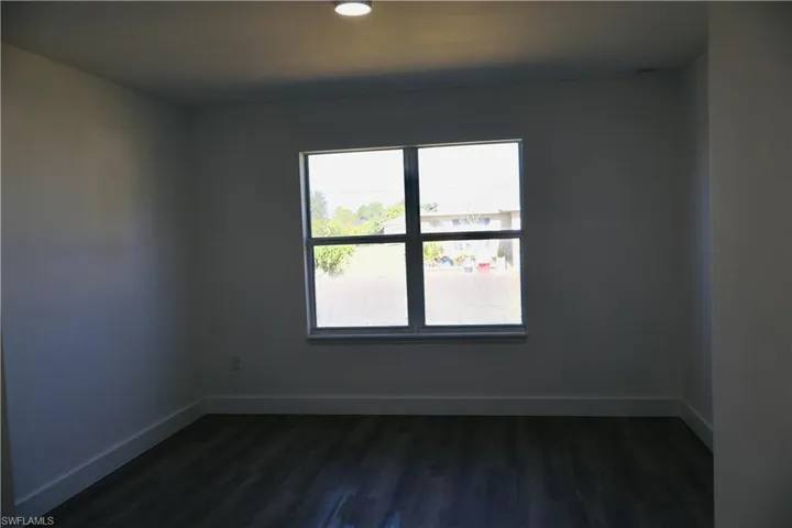 Unfurnished room with dark wood-style floors and recessed lighting