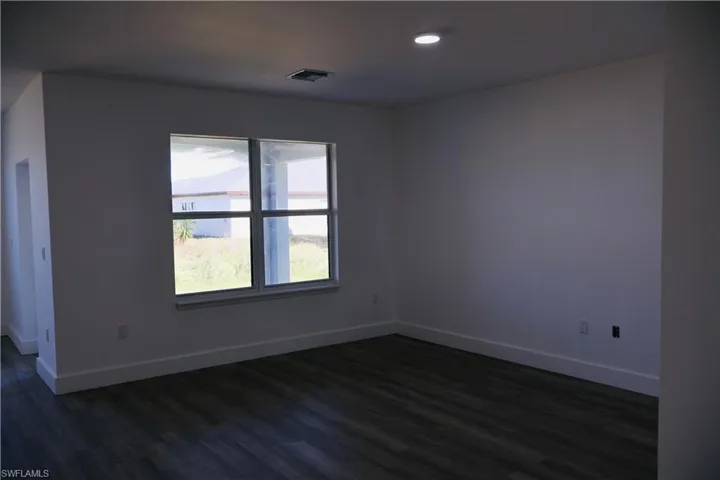 Spare room with dark wood finished floors and recessed lighting