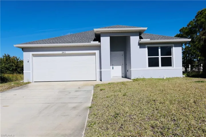 View of front of home featuring stucco siding, roof with shingles, a front lawn, concrete driveway, and a garage