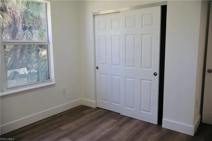 Unfurnished bedroom with dark wood-type flooring and a closet