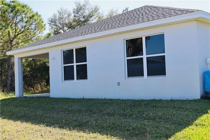 View of home's exterior with stucco siding and a lawn
