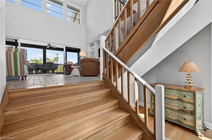 Stairway with hardwood / wood-style flooring and a high ceiling