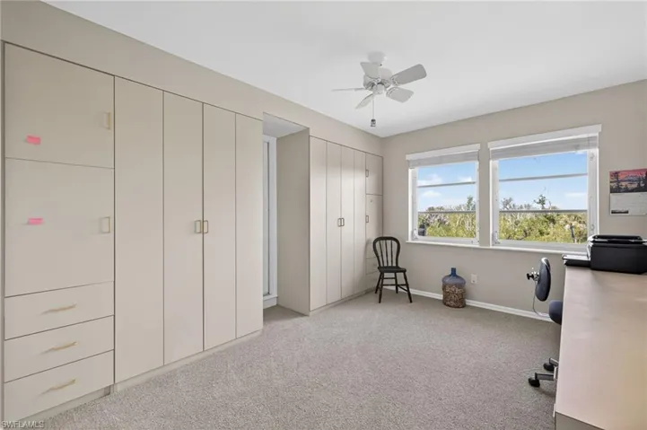 Bedroom/Office space with light carpet and ceiling fan