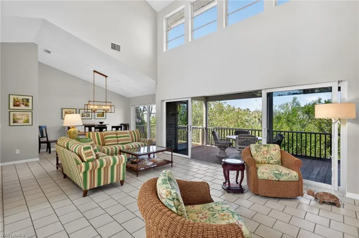 Living area featuring a high ceiling, suspended lighting, and light tile patterned floors
