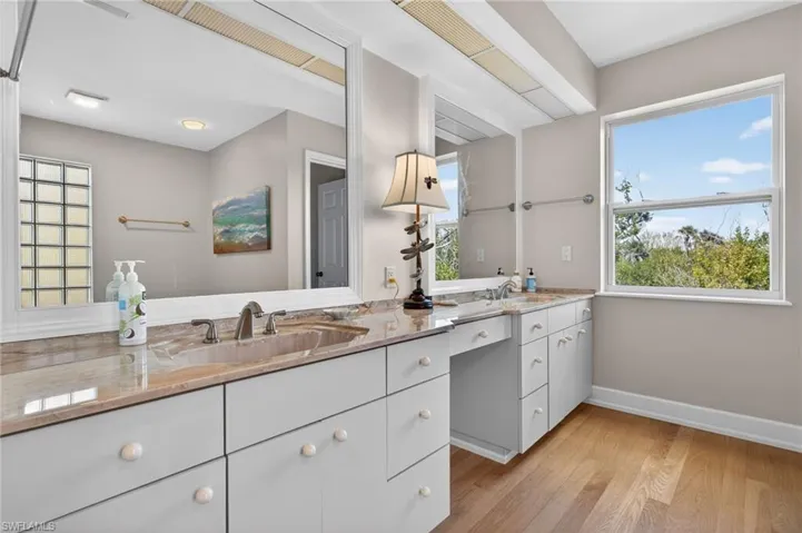 Primary Bathroom with double vanity and light wood-type flooring