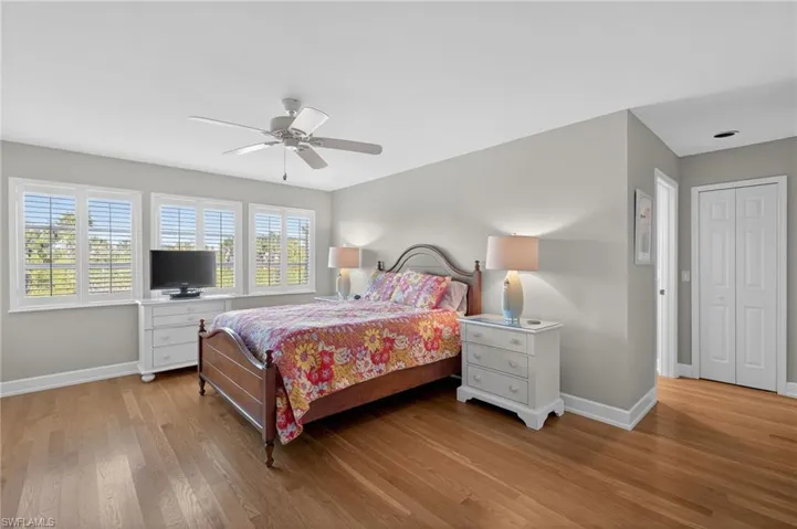 Primary Bedroom with light wood-style floors, ceiling fan, and a closet