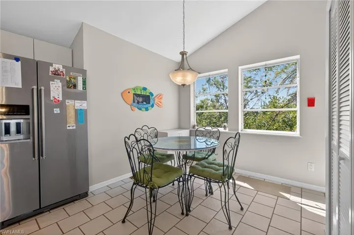 Eat-in Kitchen space with vaulted ceiling and light tile patterned floors