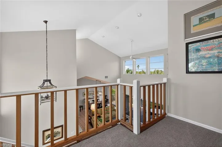 Hall featuring carpet and vaulted ceiling