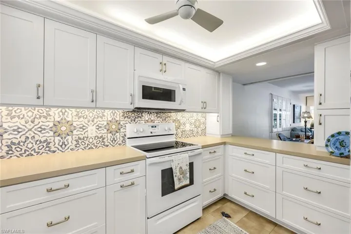 Kitchen has been redone to maximize storage, with a kitchen window, and tray ceiling. Opens to dining area with a pass-through.