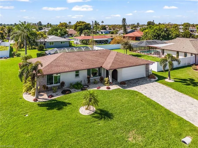 Professional tropical landscaping and paved driveway.