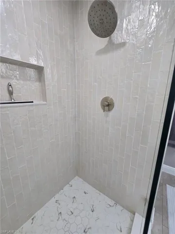 Gorgeous pealized white tile in primary bathroom