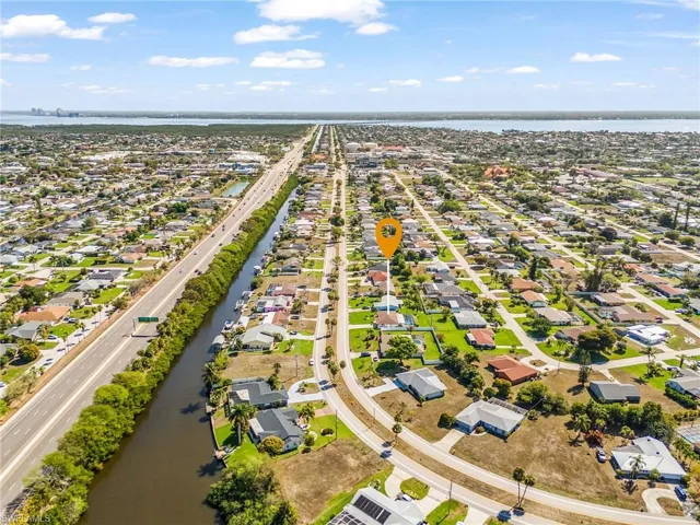 Aerial view of residences surrounded by gulf access canal and distant view of river