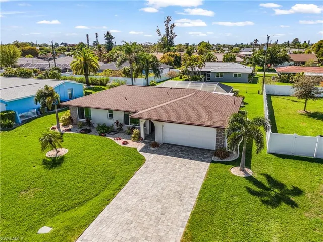 View of front of home with a garage, pavered driveway and landscaped yard