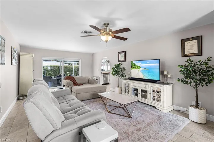 Living area featuring ceiling fan and light tile patterned flooring