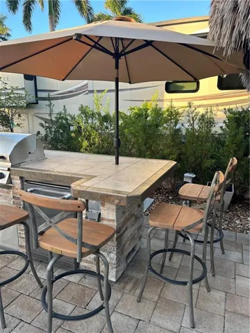 View of patio with exterior kitchen, area for grilling, and outdoor wet bar