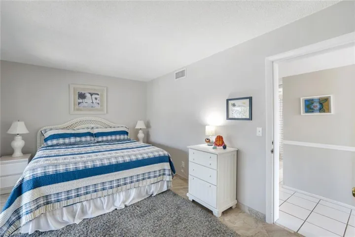 Bedroom featuring light tile patterned floors and a textured ceiling