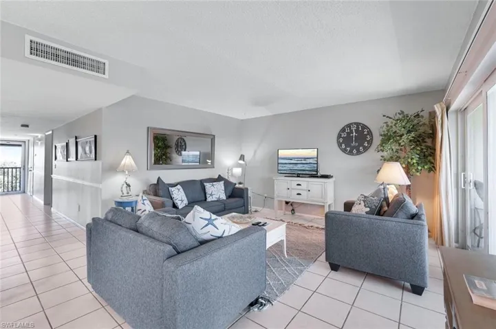 Living room with light tile patterned floors and a textured ceiling