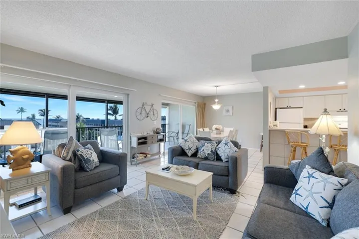 Living room with light tile patterned floors and a textured ceiling