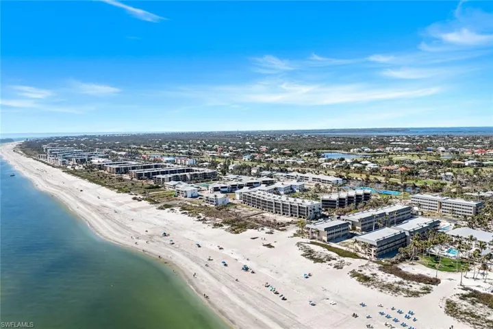 Birds eye view of property with a beach view and a water view