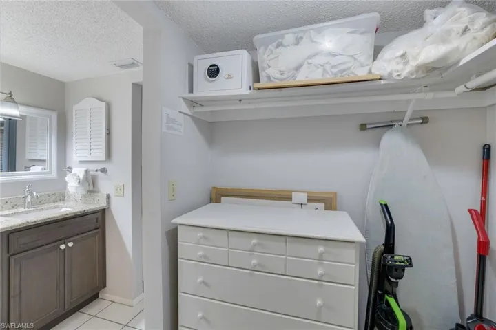 Bathroom with tile patterned floors, vanity, and a textured ceiling
