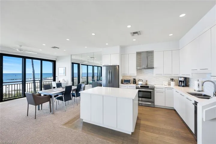 Kitchen with a center island, white cabinetry, stainless steel appliances, backsplash, and modern cabinets