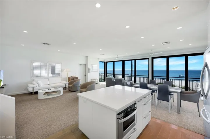 Kitchen featuring white cabinetry, open floor plan, a water view, stainless steel appliances, and recessed lighting