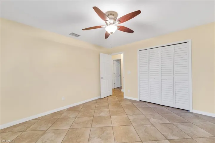 Unfurnished bedroom featuring ceiling fan, a closet, and light tile patterned floors