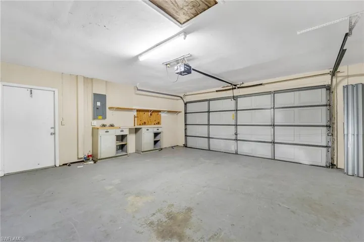 Garage featuring electric panel and a garage door opener