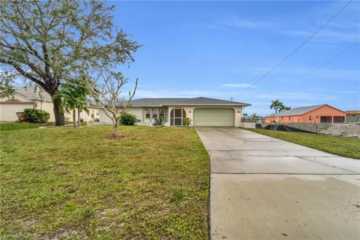 Single story home with concrete driveway, stucco siding, and a garage