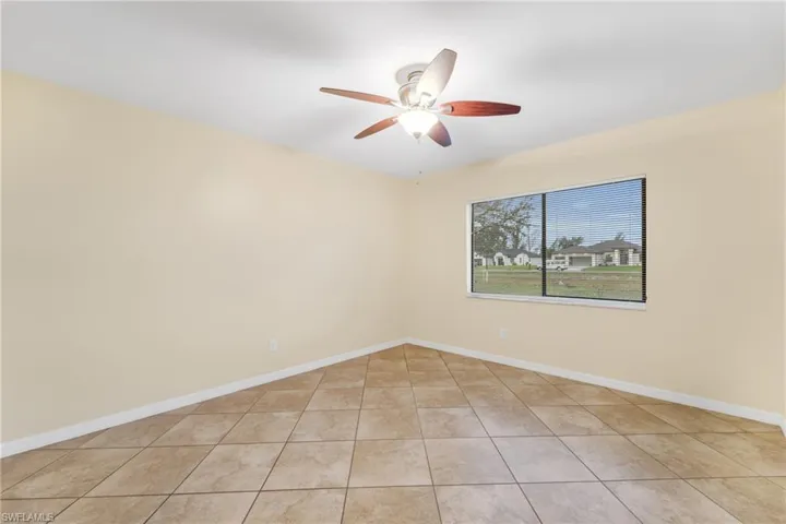 Unfurnished room with a ceiling fan and light tile patterned flooring