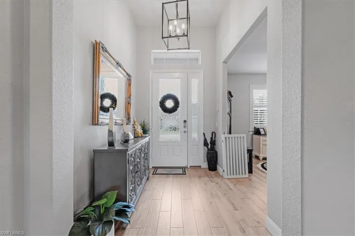 Foyer featuring light hardwood / wood-style floors and an inviting chandelier